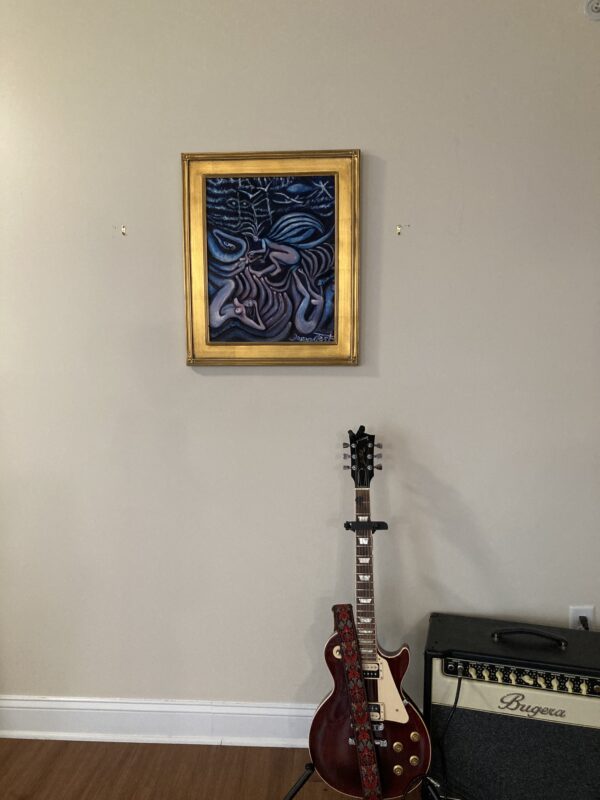 A guitar and a painting on the wall