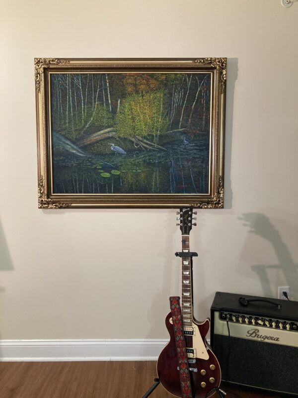 A guitar and an electric guitar in front of a painting.