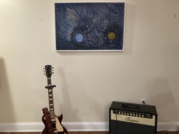 A guitar and a picture hanging on the wall