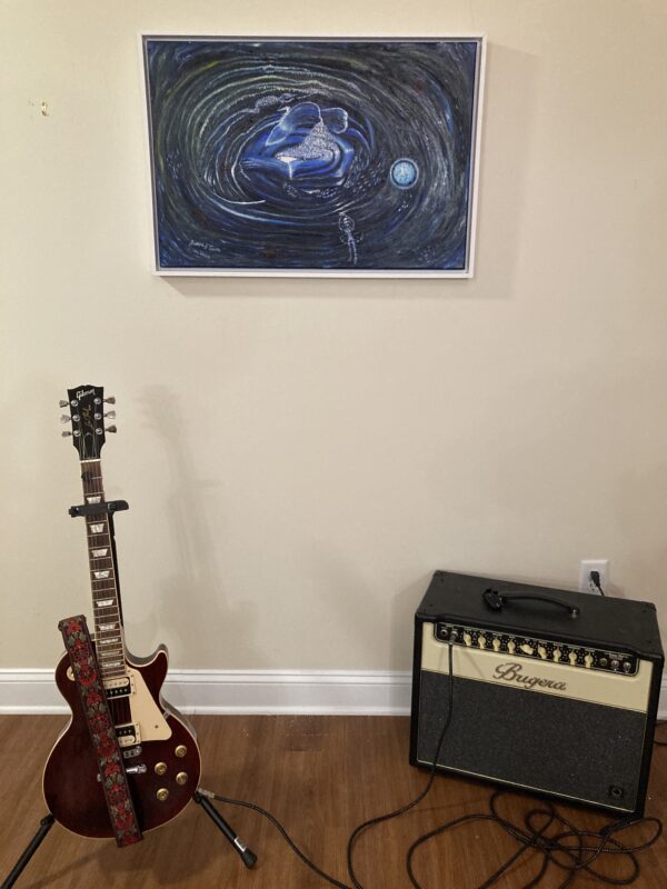 A guitar and an amp in front of a wall.