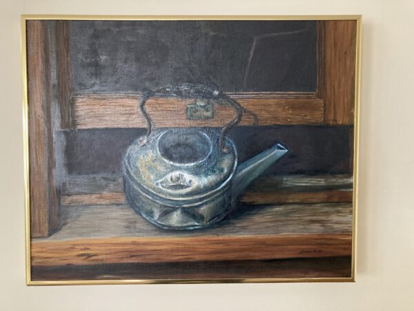 A painting of an old tea pot on the counter.