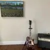 A guitar sitting in front of a painting.